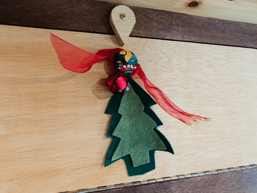 Christmas tree ornament with a red ribbon hanging on a van drawer