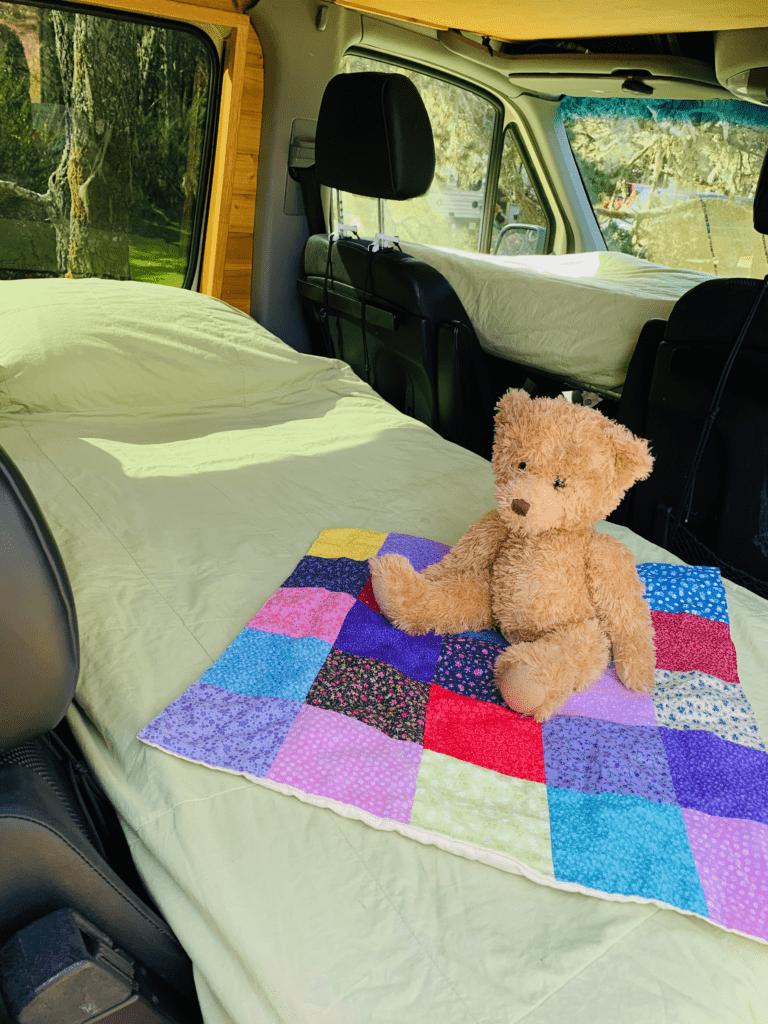 van double bunk system with comfortable twin size beds and teddy bear on a small quilt