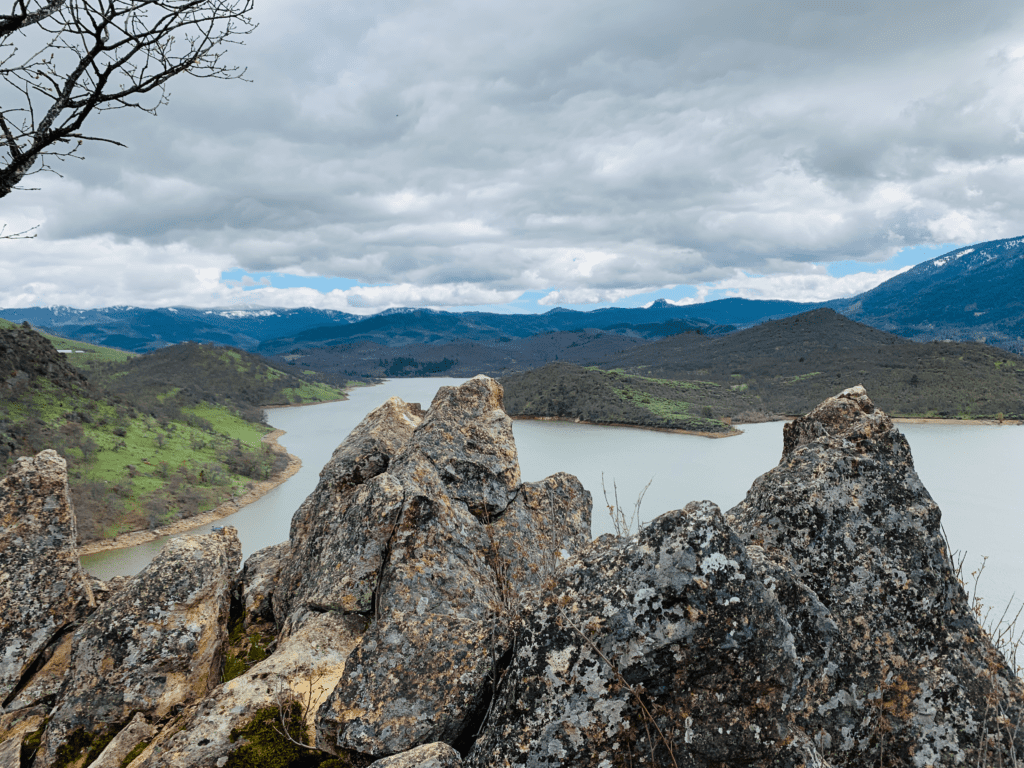 At the summit of a trail in the Rogue Valley with volcanic rock and Emigrant Lake in the background