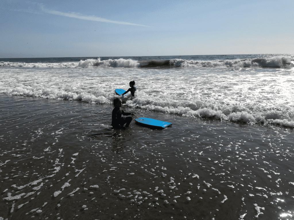 Kids having fun boogie boarding in the ocean in Santa Cruz