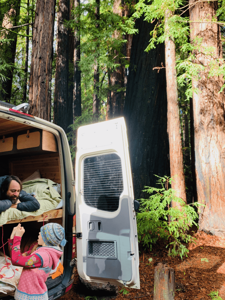 Van back doors in fresh Redwood Forest air with dad and daughter talking in the background