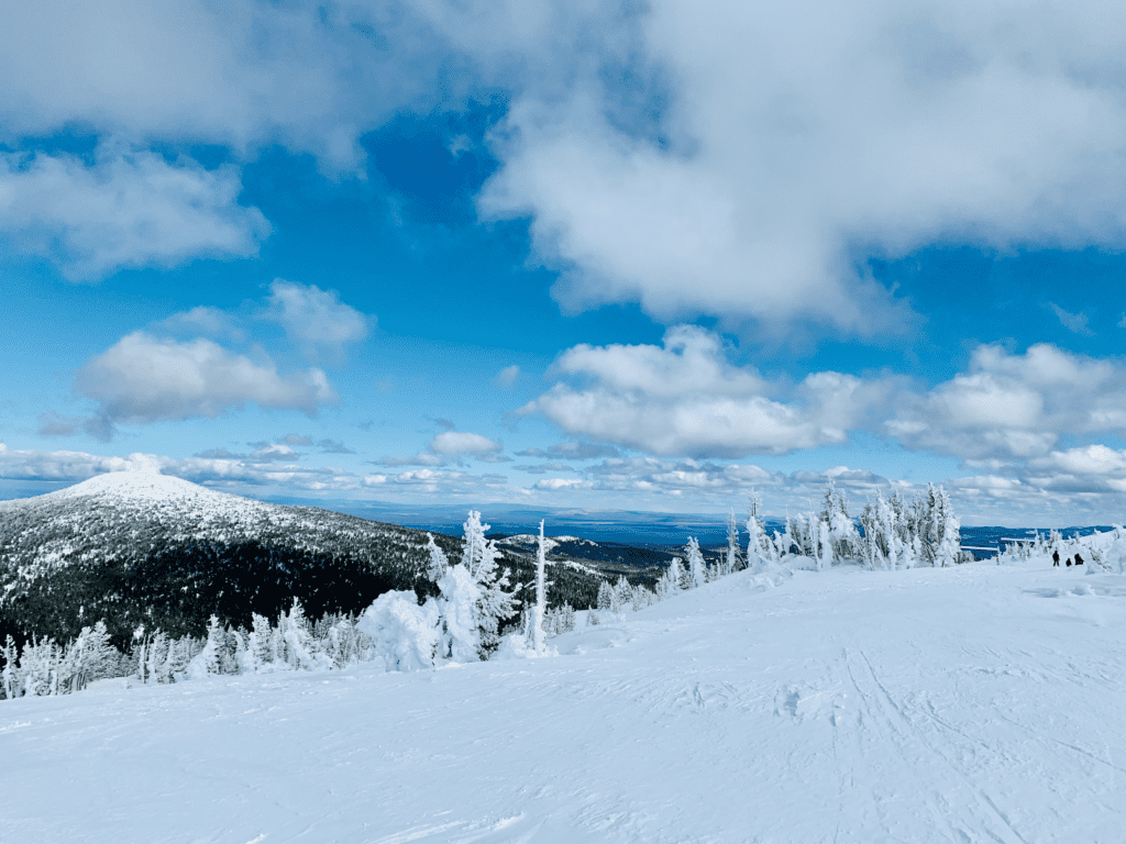 Mt Bachelor Winter Wonderland in Bend with the white rolling Cascade hills and blue white cloud skies in the background