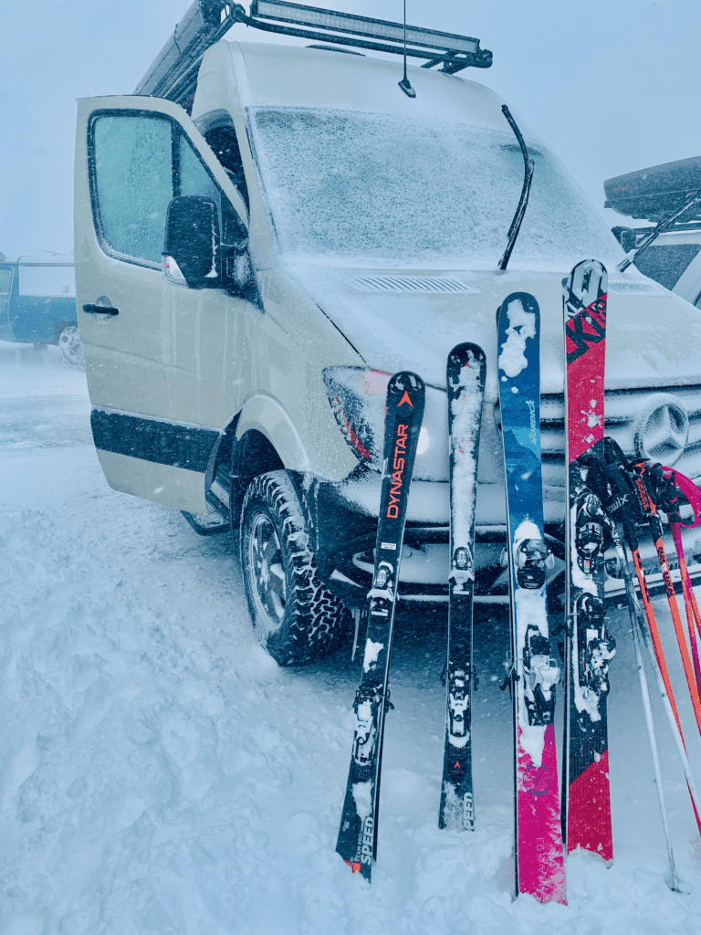 Van is the Best Ski Lodge on Wheels skis learning against the front of van During Winter Storm ice and limited visibility