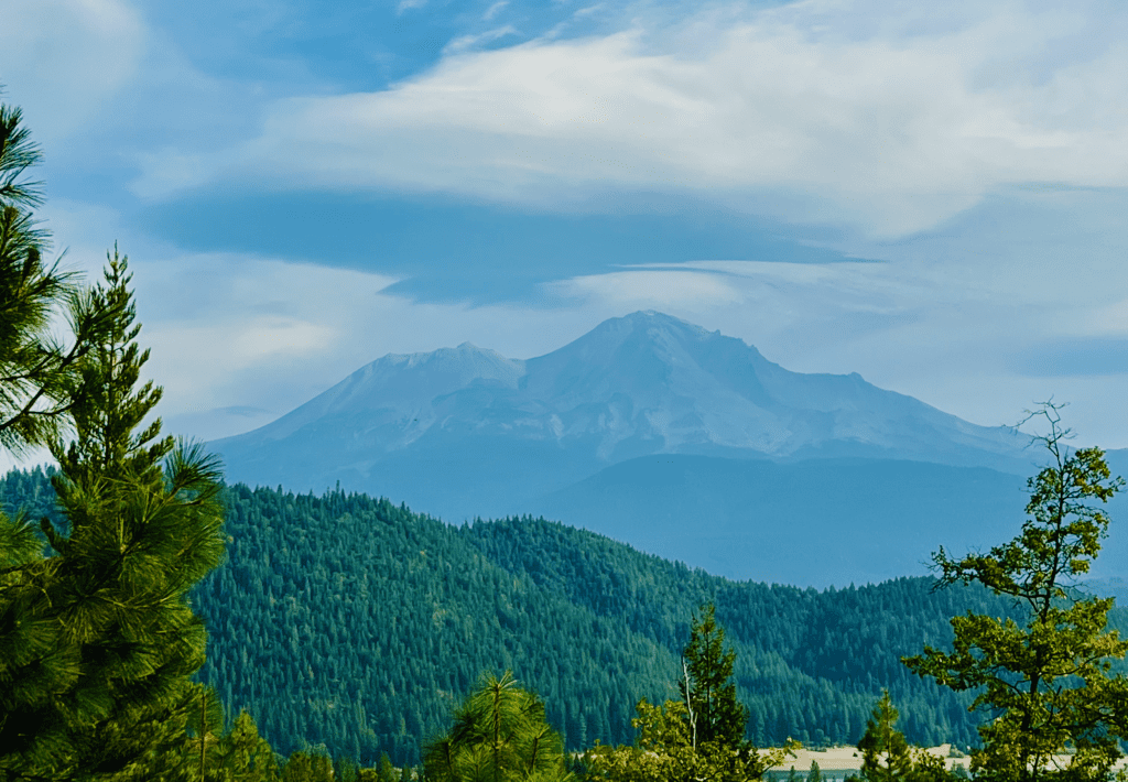 A barren no snow rock face Mount Shasta in the Autumn with thick lenticular clouds in the background