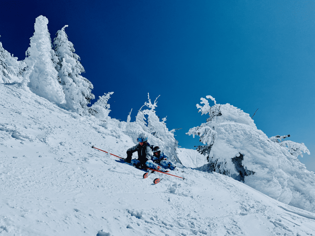 Kids resting on Mount Bachelor Ski Backside up in the Alpine with hoarfrost trees in the background