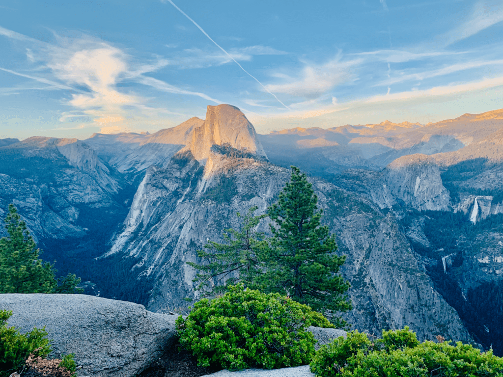 Half Dome View from Glacier Point with granite rocks cloud streaks and sunset in the background