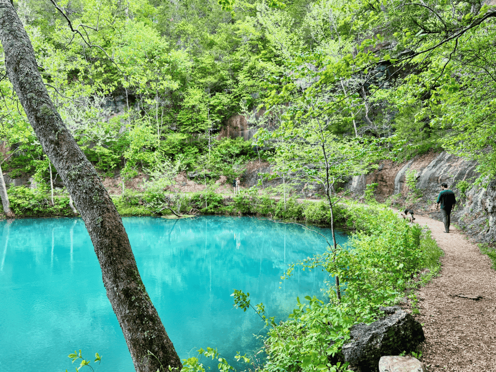 Van kids exploring the Ozarks with breathtaking luminescent pool at Alley Mill walking on a curved trail at Ozark National Scenic Riverway